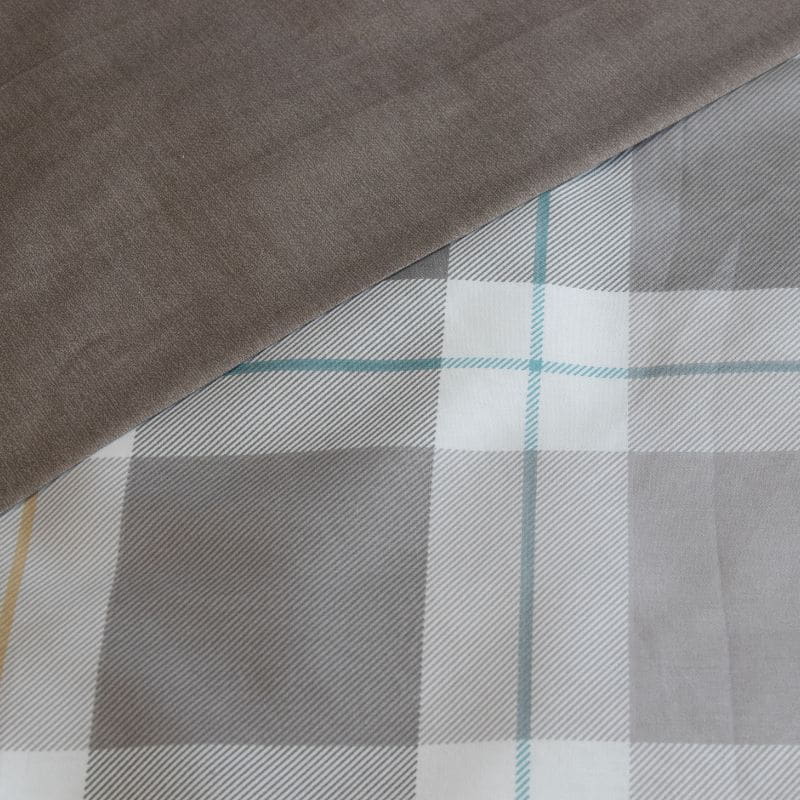 Close-up details of a quilt cover designed with soft greys combined with subtle pops of colour are the perfect way to add a touch of vibrance to your space.