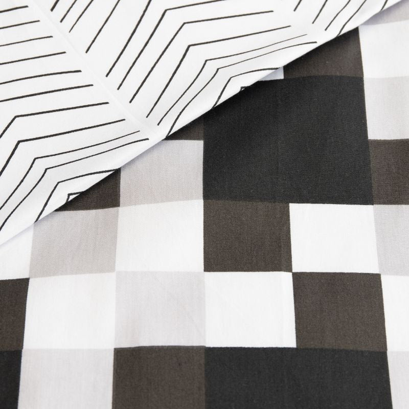 Close-up details of a black and white quilt cover set with checkered pattern and subtle geometric reverse, perfect for a unique style.