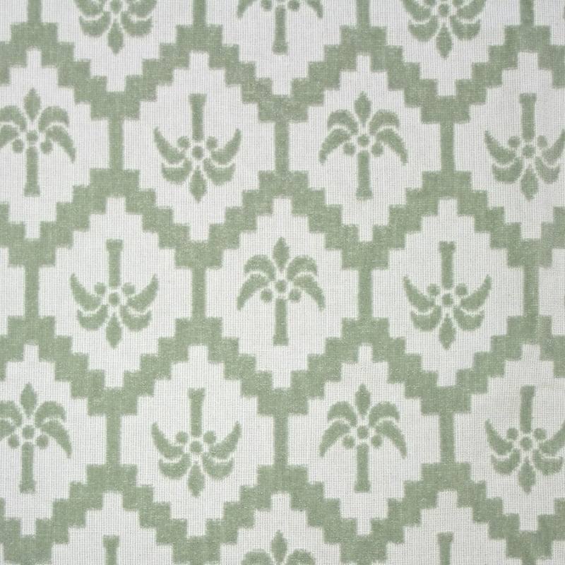 alt="Close-up view of a kids sage green poncho featuring a stylish palm tree pattern with knotted tassels along the ends"