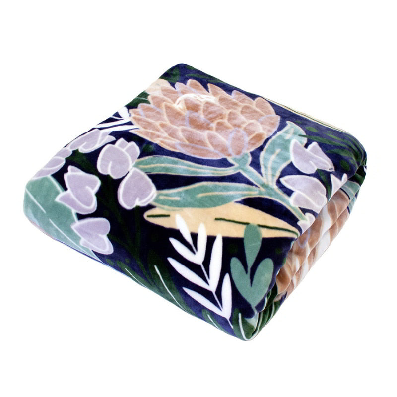 Folded protea print blanket on a navy blue backdrop, satin binding, double layer for warmth and cosiness.