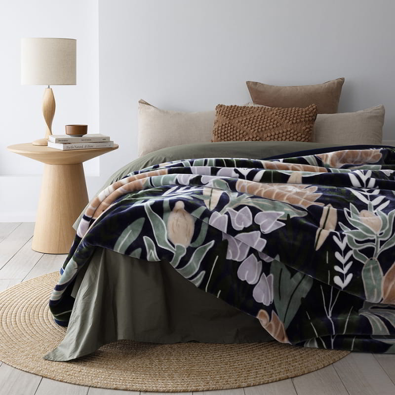 Stunning protea print blanket on a navy blue backdrop, satin binding, double layer for warmth and cosiness.