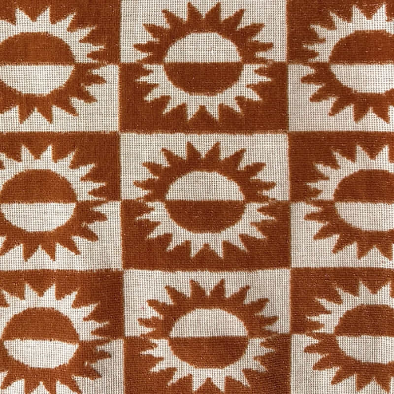 alt="Close-up view of a kids brown poncho featuring a stylish sun pattern with knotted tassels along the ends"