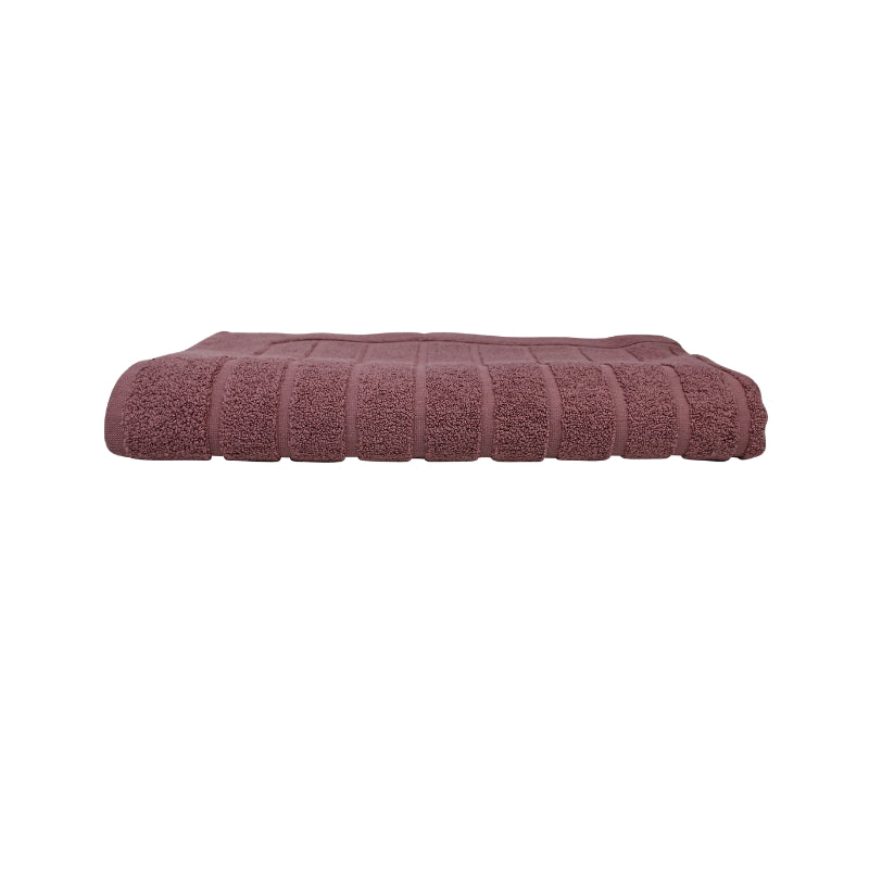 alt="The dusty rose Zero Twist bath mat unveils intricate folded details, adding a luxurious touch to your bathroom"