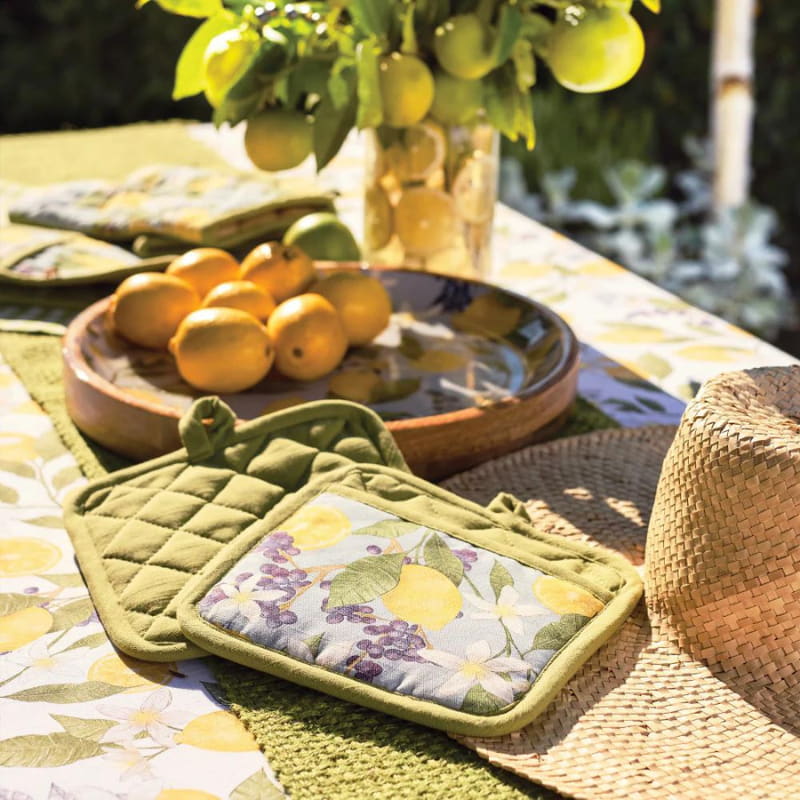 alt=" a fresh and vibrant greened themed table arrangement featuring the 2 pot holders atop a buri hat along with the lemons"