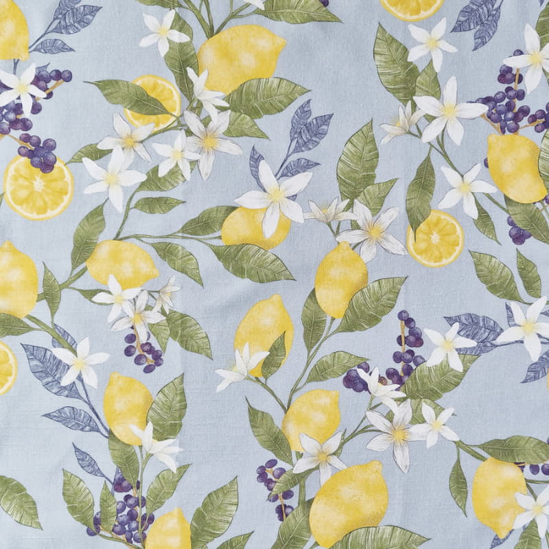 alt="a close up details of a blue fabric printed with lemon and white flowers"