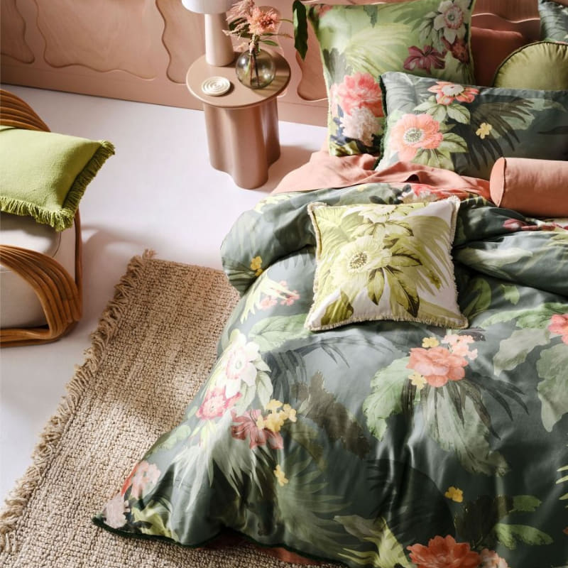 alt="Top view of cotton quilt cover set outlined an archival tropical print in a cosy bedroom"