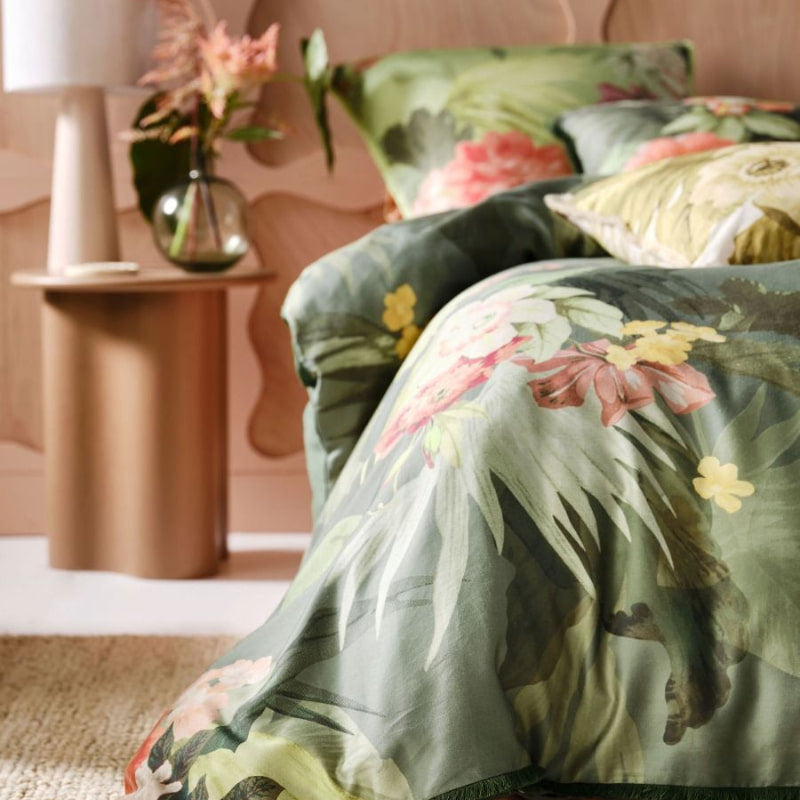 alt="Closer view of cotton quilt cover set outlined an archival tropical print in a cosy bedroom"