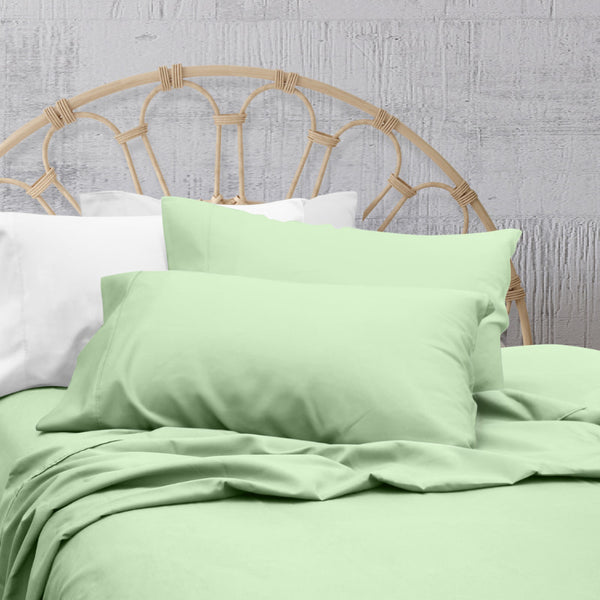 A clean and classic light green bed with matching sheets and pillows on a cosy bedroom, made of 100% microfibre for a soft and warm feel.
