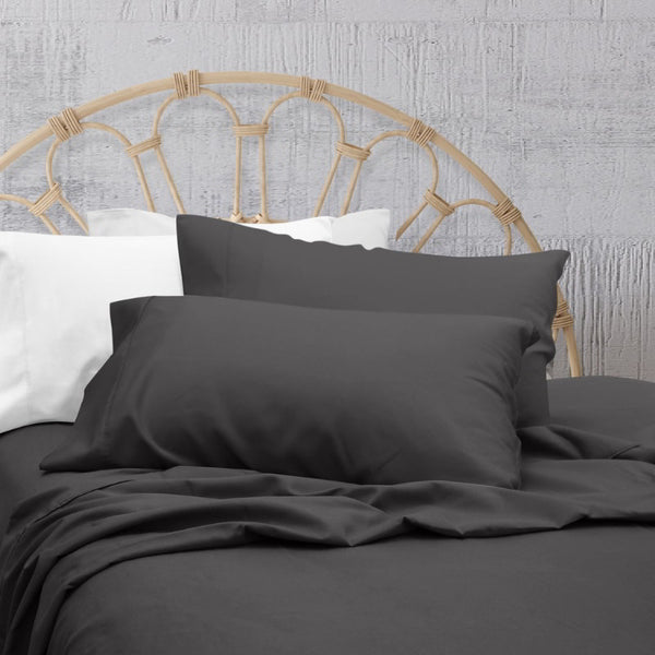 A clean and classic charcoal-toned bed with matching sheets and pillows on a cosy bedroom, made of 100% microfibre for a soft and warm feel.