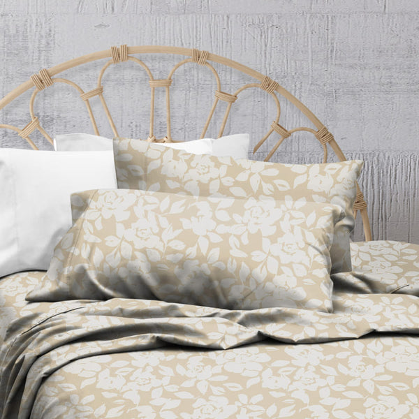 A natural-toned bed sheets and pillows, adorned with a monochromatic white floral and foliage pattern, craft a serene and unique design.
