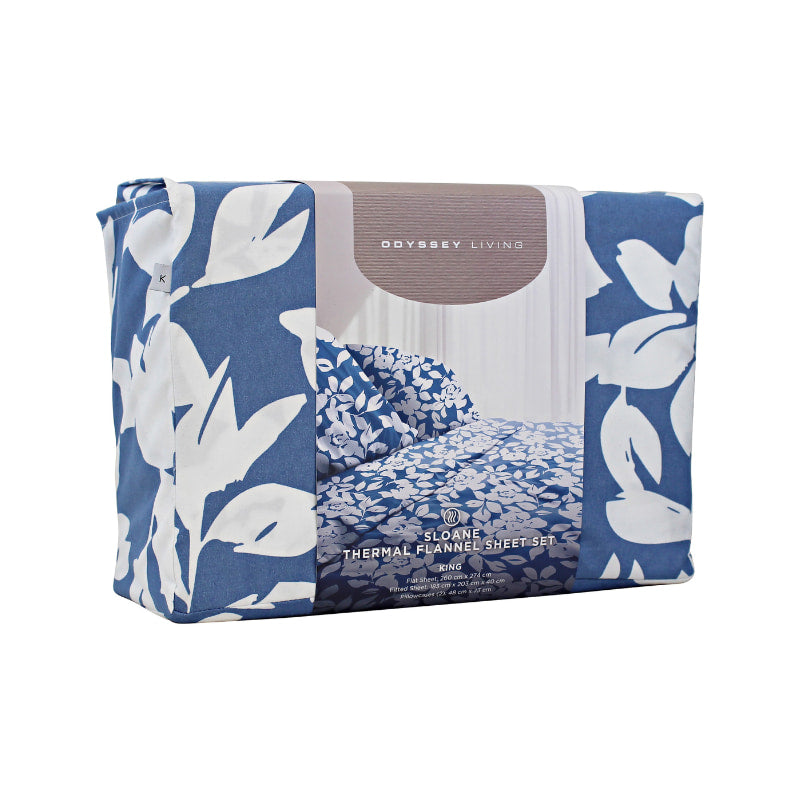 Side packaging details of a blue bed sheets and pillows, adorned with a monochromatic white floral and foliage pattern, craft a serene and unique design.