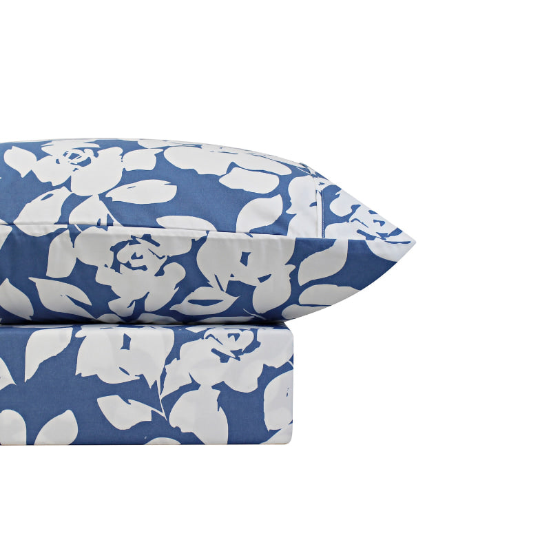 A blue bed sheets and pillowcase, adorned with a monochromatic white floral and foliage pattern, craft a serene and unique design.