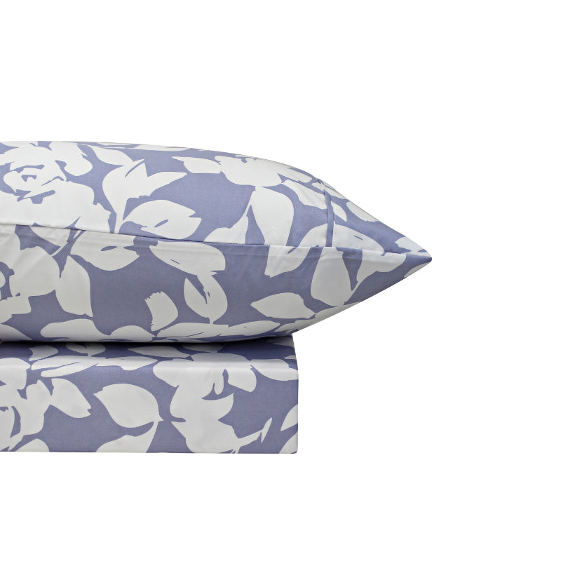A lavender-toned bed sheets and pillowcase, adorned with a monochromatic white floral and foliage pattern, craft a serene and unique design.
