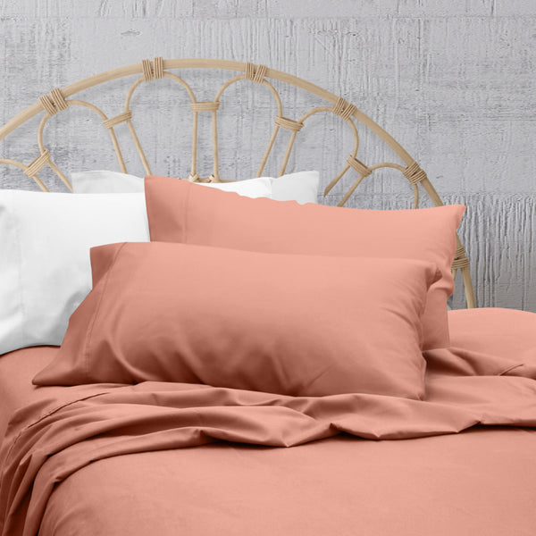 A clean and classic orange bed with matching sheets and pillows on a cosy bedroom, made of 100% microfibre for a soft and warm feel.