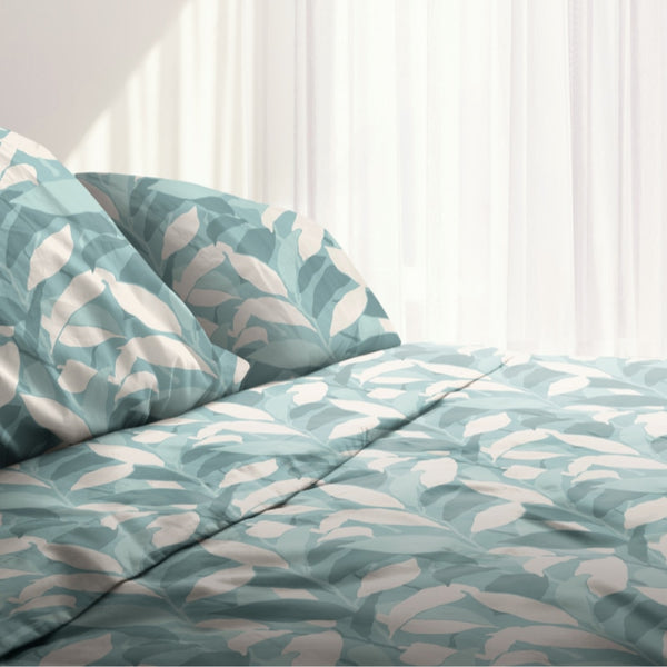 A cosy bed with a teal and white sheet set from Odyssey Living, featuring a modern abstract pattern in teal and white tones.