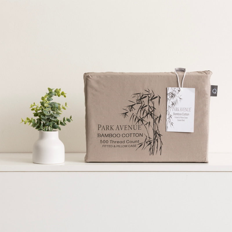 alt="A light brown packaging with a plant on it next to a vase. Experience the soft and gentle extra soft bamboo cotton blend combo set with a satin finish. Naturally breathable, protects skin, machine washable."