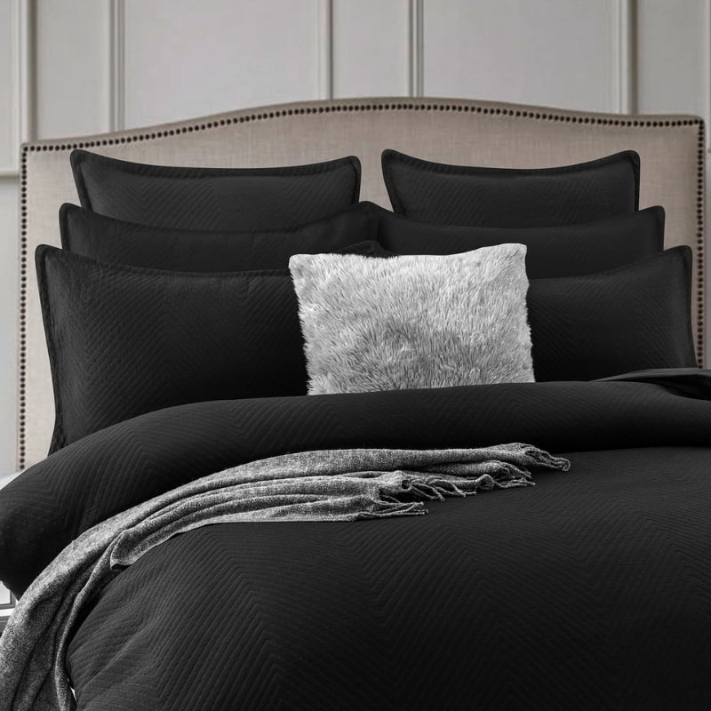 alt="Showcasing a quilt cover and european pillowcases featuring an embossed design with a sham edge deep black in a cosy bedroom"