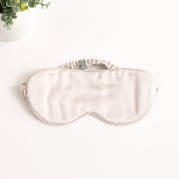 alt="A shade of sand silk eye mask with 6 layers of soft padding, made from 100% pure mulberry silk. Gentle on skin, prevents wrinkles, and hydrates."