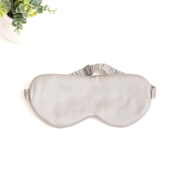 alt="Silver silk eye mask with 6 layers of soft padding, made from 100% pure mulberry silk. Gentle on skin, prevents wrinkles, and hydrates."