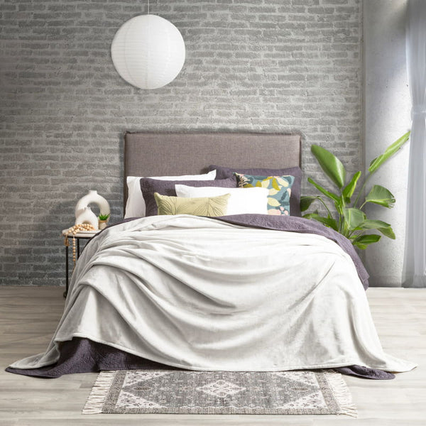 Lavish bed adorned with a pristine silver line color ultra soft velvet blanket and generously oversized.