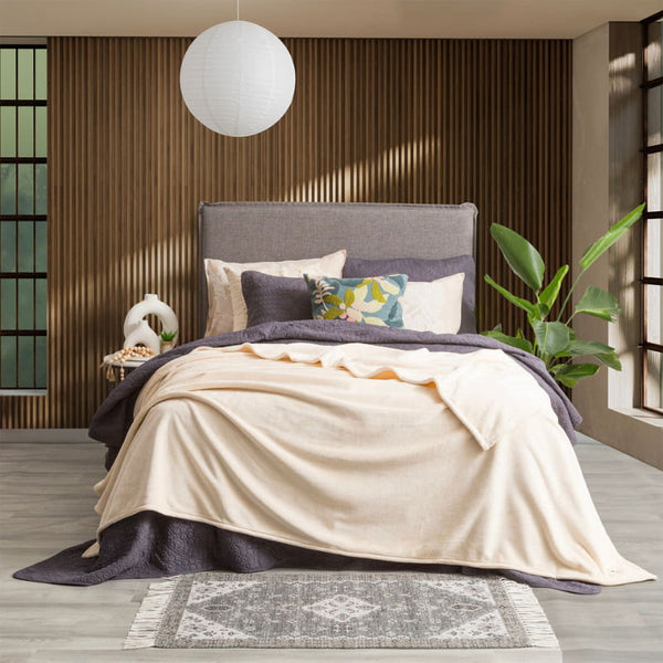 Lavish bed adorned with a pristine sand color ultra soft velvet blanket and generously oversized.