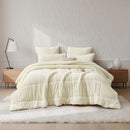 An ivory Snuggle Fleece Comforter set styled in a bright bedroom with a soft rug and timber accents for a calm, welcoming feel.