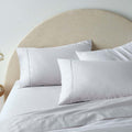 "A white, superior-quality cotton sheet set in a cosy bedroom"