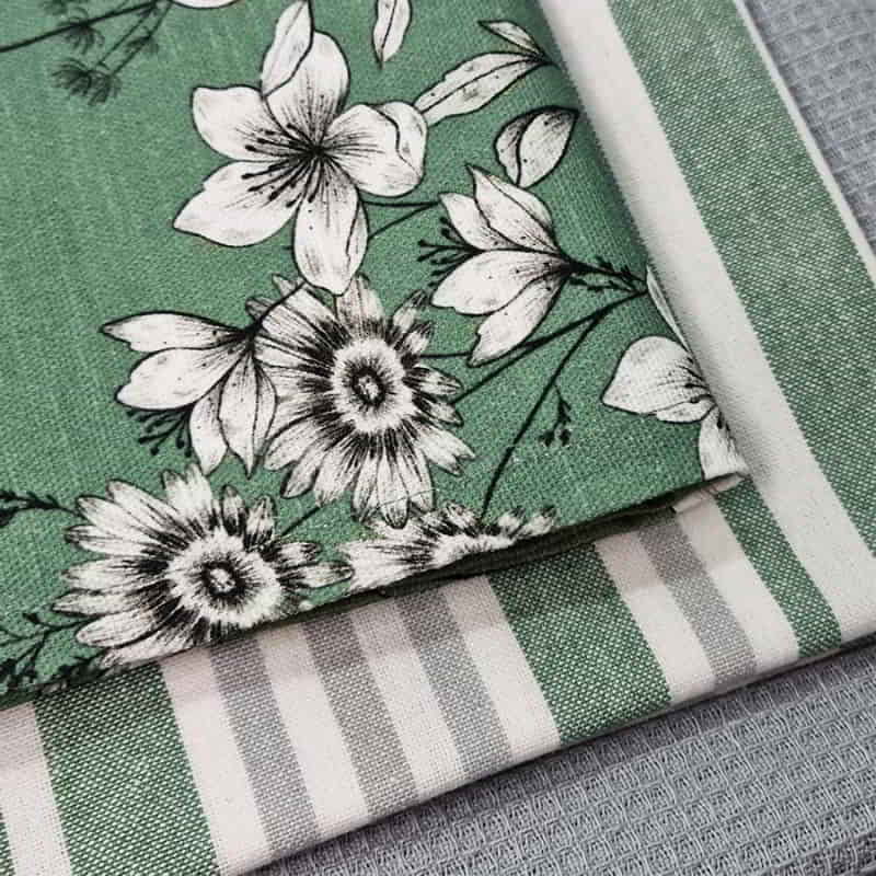alt="Zoom in details of the set of green tea towels feature one printed design, one striped design and one plain waffle."