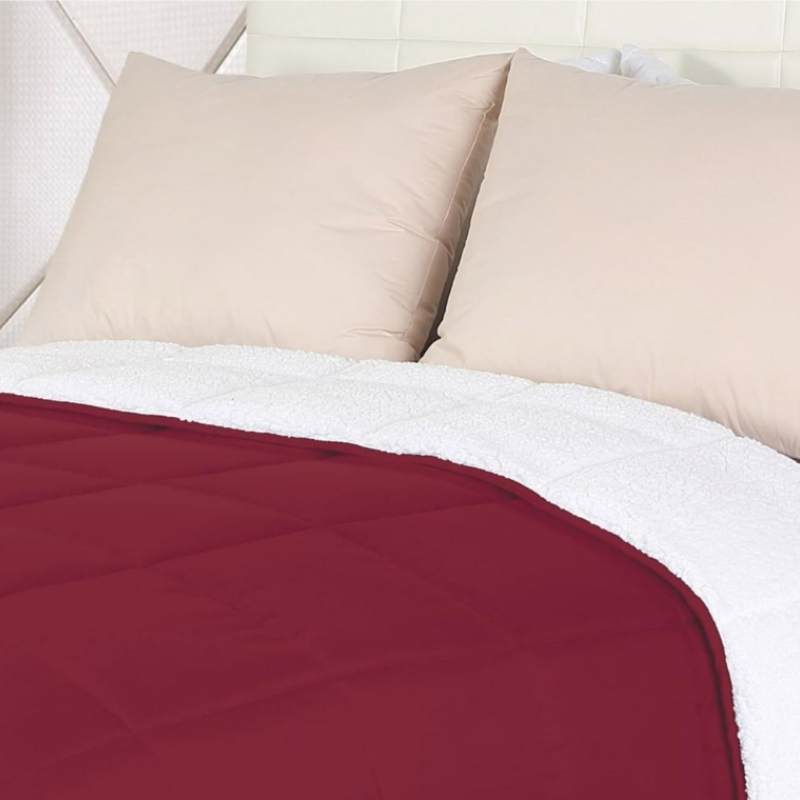 Close up details of a cosy red comforter featuring a reversible design and high-quality materials for a warm and luxurious sleeping experience.