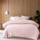 Blush bamboo cotton quilt cover styled on a neatly made bed with pillows