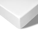 Folded corner of the coverlet showing smooth weave and light drape across the bed