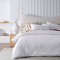 alt="A white quilt cover set featuring a stunning timeless jacquard design in an elegant bedroom setting."