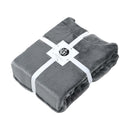 alt="Super soft grey hooded blanket with a cosy design, featuring a hood and large front pocket in the same plush material in a packaging"