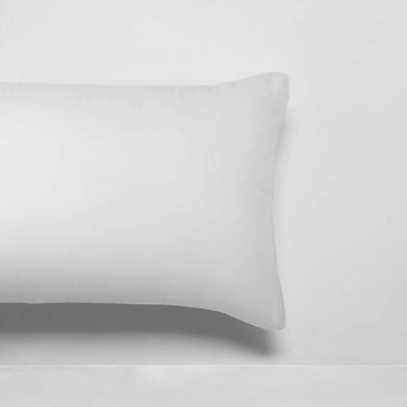 alt="Close up look of white deluxe cotton sheet set and pillowcase in a cosy bedroom"
