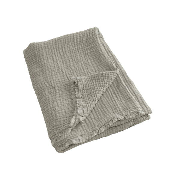 alt="A natural throw featuring a 4 layer gauze cotton fabric with natural frayed edge"