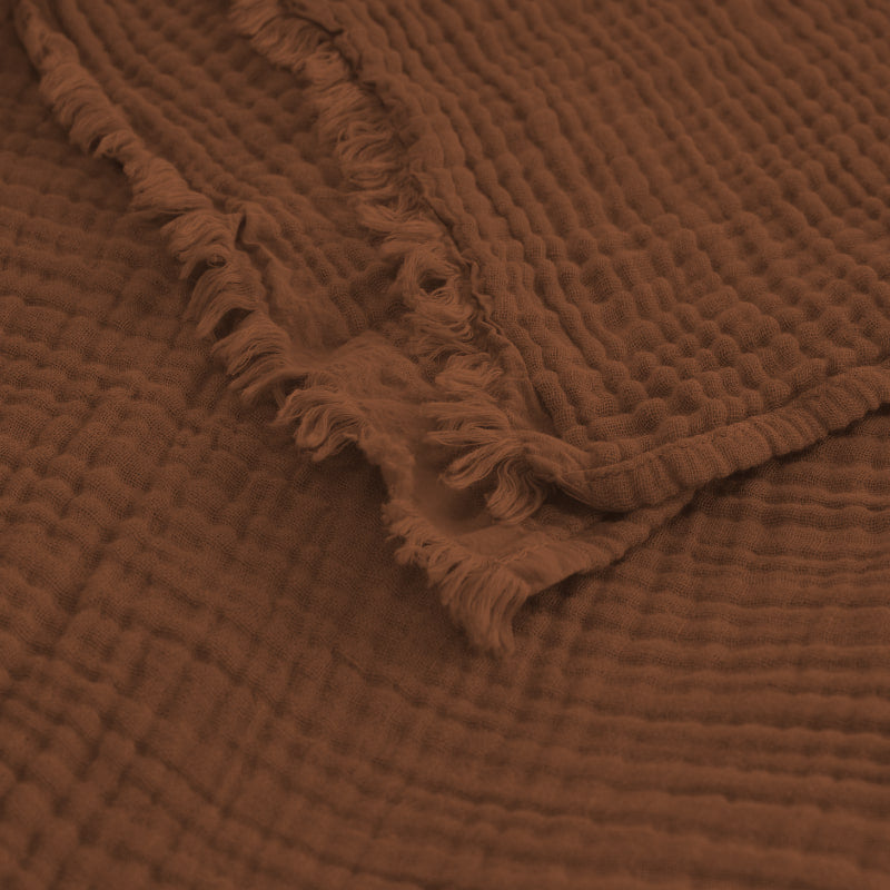 alt="Zoom in details of a natural throw featuring a 4 layer gauze cotton fabric with natural frayed edge"