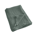 alt="A green throw featuring a 4 layer gauze cotton fabric with natural frayed edge"