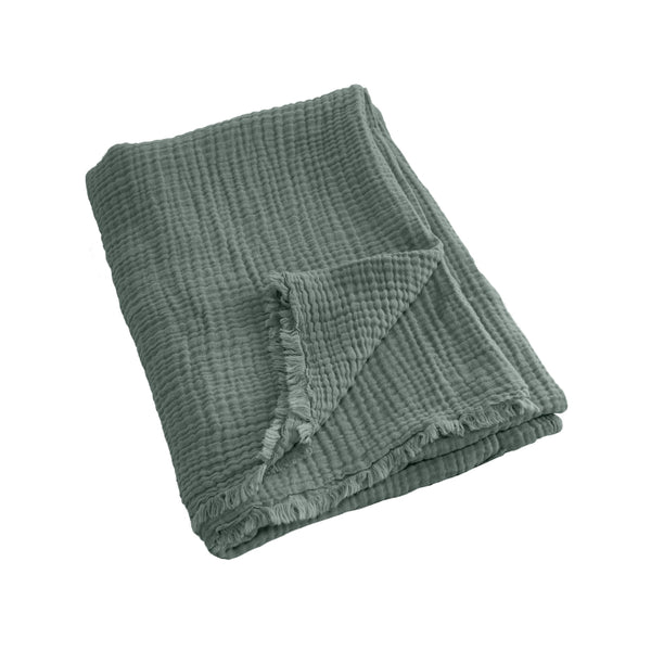 alt="A green throw featuring a 4 layer gauze cotton fabric with natural frayed edge"