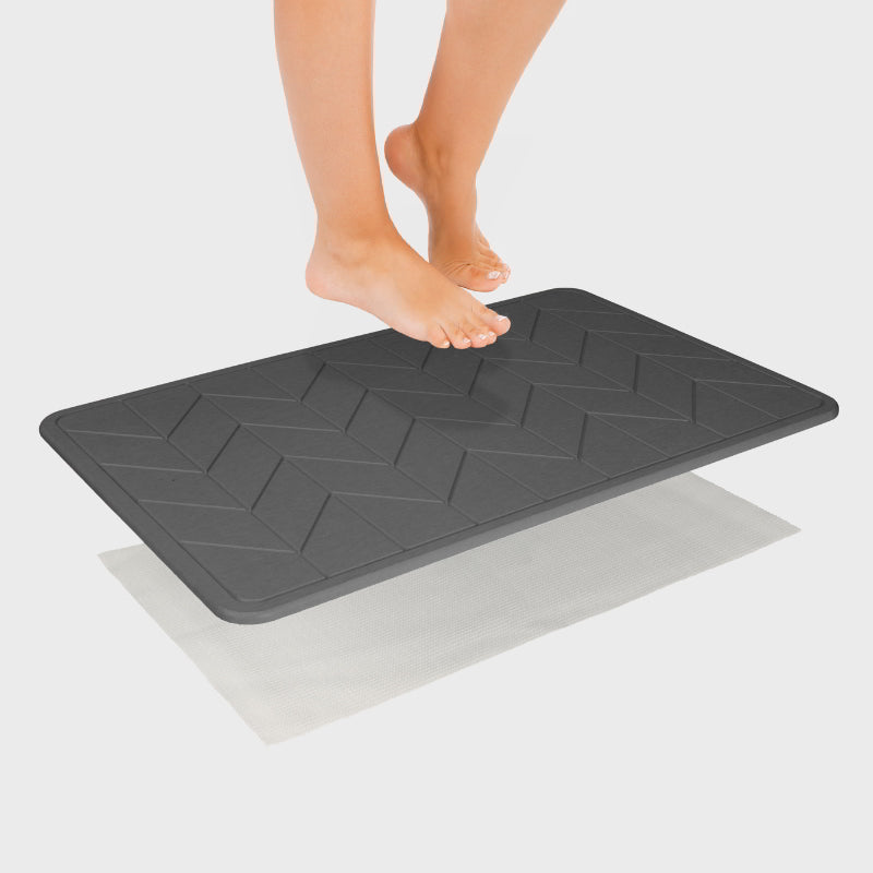 Someone is stepping at a bath stone with its super porous surface, keeps your floor clean and dry, minimizing bacteria growth.