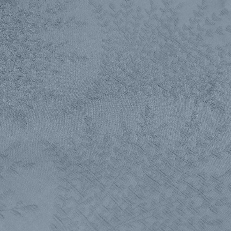 Detailed view of an elegant blue fabric adorned with a leaf pattern, perfect for adding a touch of sophistication to your bedroom's aesthetic.