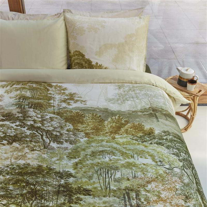 alt="Close-up look of a quilt cover set designed with an idyllic hand-painted landscape of wooded hills with trees"