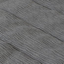 Detailed view of a stylish grey bed with crinkled textures and vintage frayed edges, perfect for winter bedding.