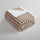 Carter boucle throw folded on a bed with soft textured finish