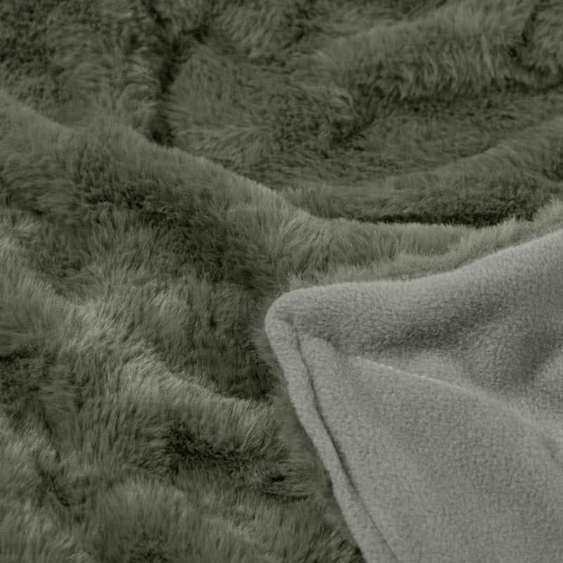 Detailed shot of a luxurious khaki throw with a soft, plush texture and earthy colour, featuring a green throw with a black trim.