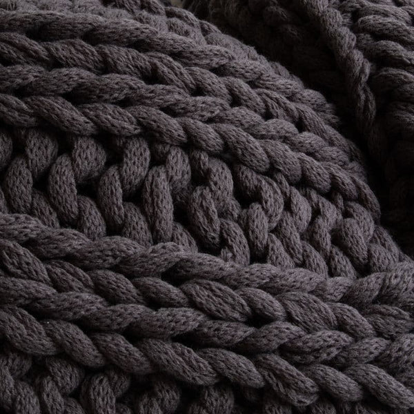 Close-up details of a cosy and textured grey throw, a great gift idea for this season.