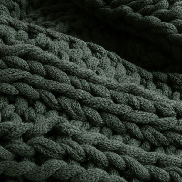 Close-up view of the cosy and textured green throw, a great gift idea for this season.