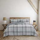 Cosy bed featuring a grey quilt cover, adding timeless charm and warmth to your bedroom decor.
