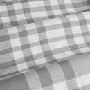 Detailed view of a grey checkered fabric, highlighting the timeless plaid pattern ideal for a warm bedroom vibe.