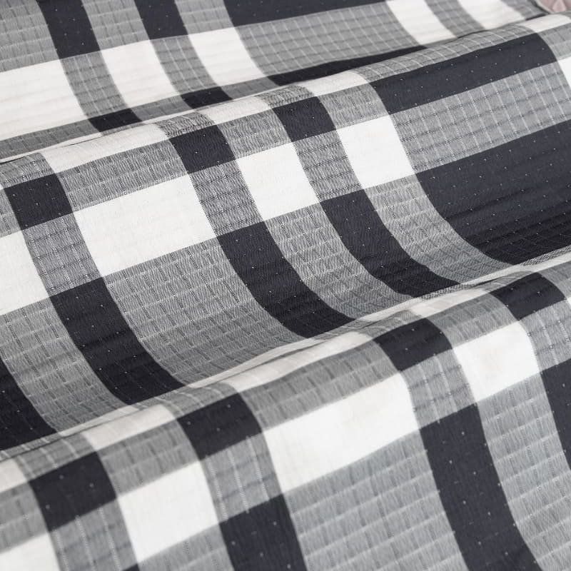 A stylish bed featuring a navy quilt cover set, enhancing the room's charm and comfort for relaxation.