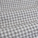 Close-up of a grey checkered fabric, showcasing a cosy gingham pattern perfect for a warm bedroom vibe.